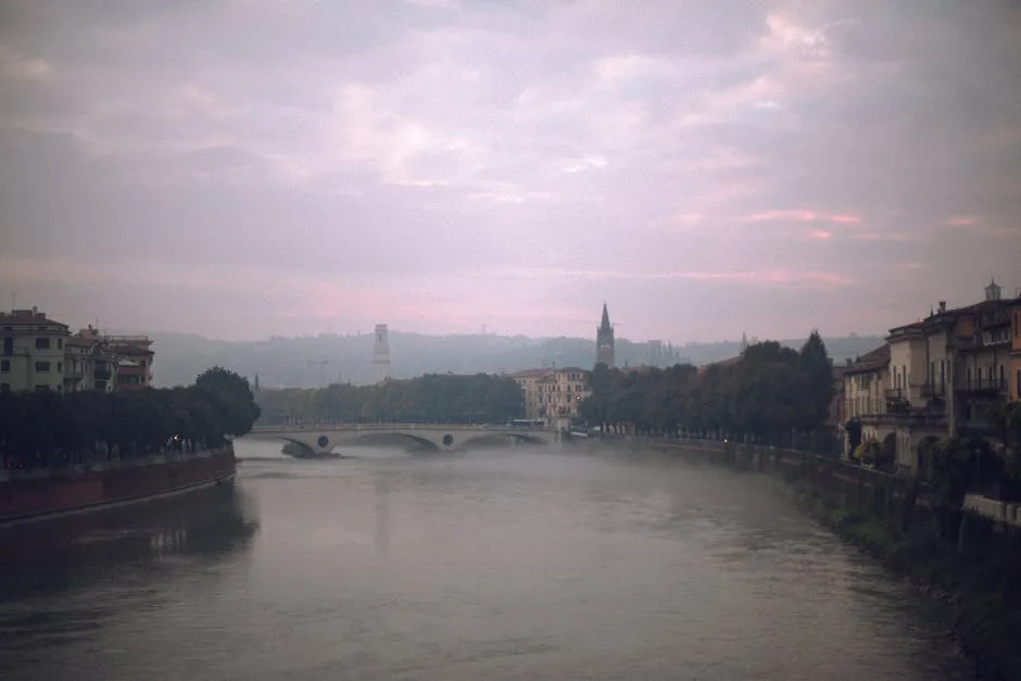 Morgennebel über dem Adige in Verona, Brücke und ferne Silhouetten