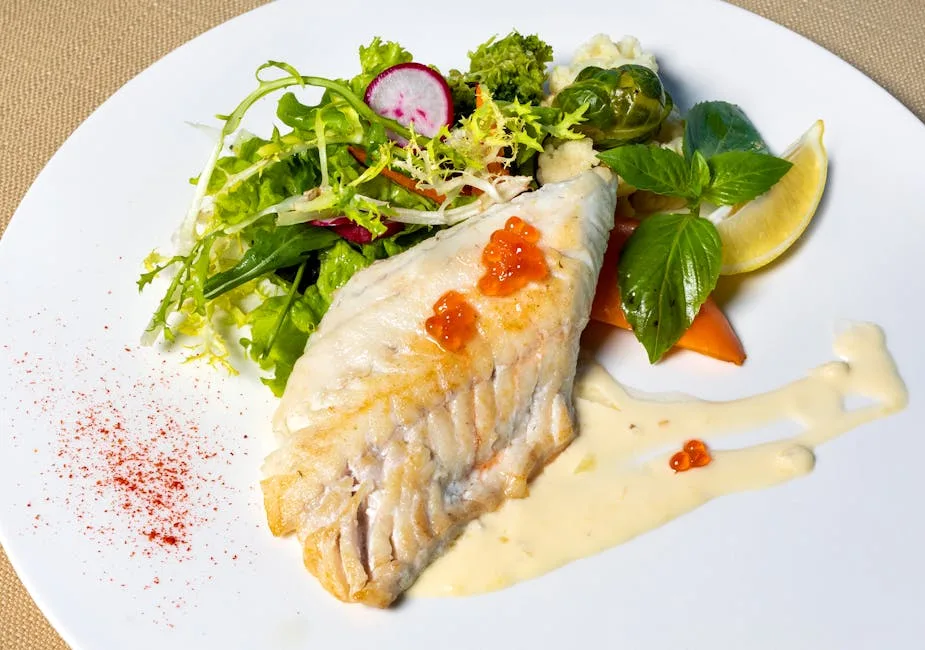 Gegrilltes Fischfilet mit frischem Salat, Sauce und Zitronenschnitz in Verona