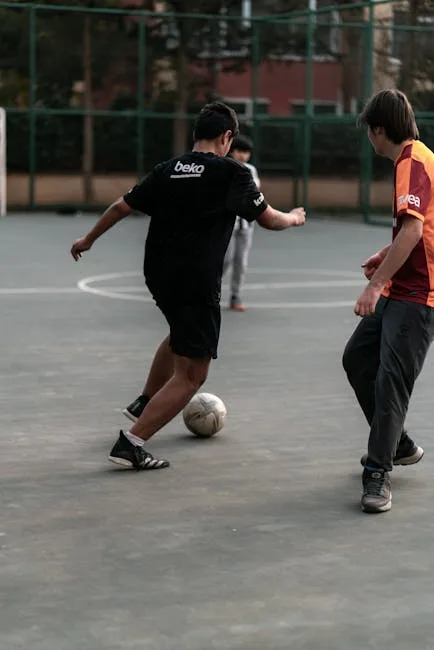 Teenager dribbeln einen Ball auf einem städtischen Multisportfeld