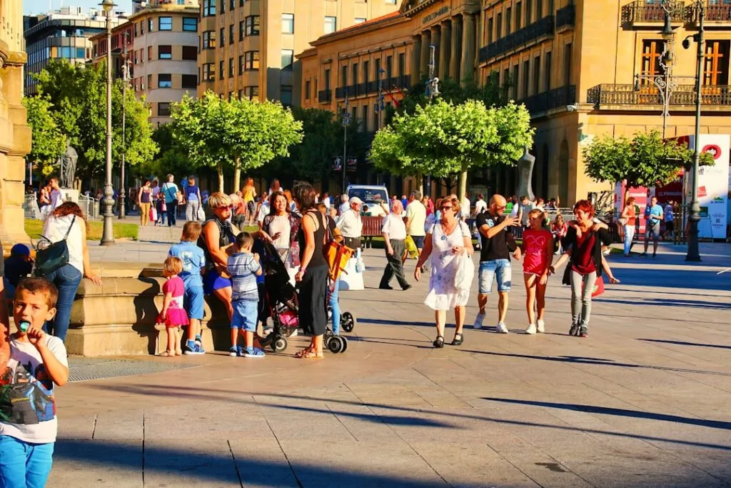 Belebter Platz mit Familien, Kindern und Bäumen im Stadtzentrum.