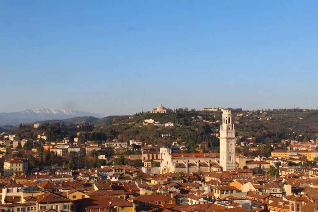 Panorama über Veronas Dächer mit markantem Kirchturm und Hügeln