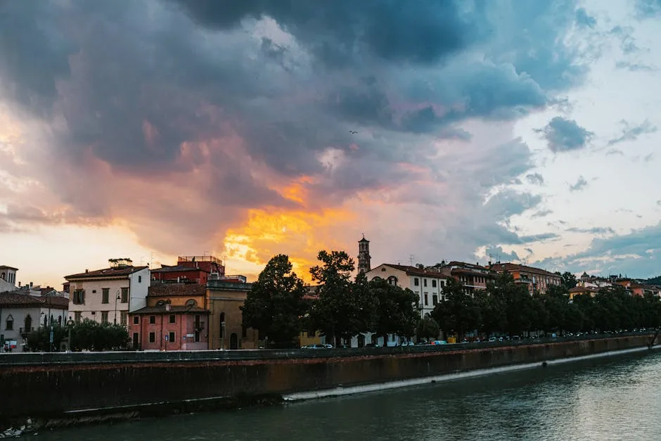 Rivieroever van de Adige in Verona met kleurrijke zonsondergang en wolken