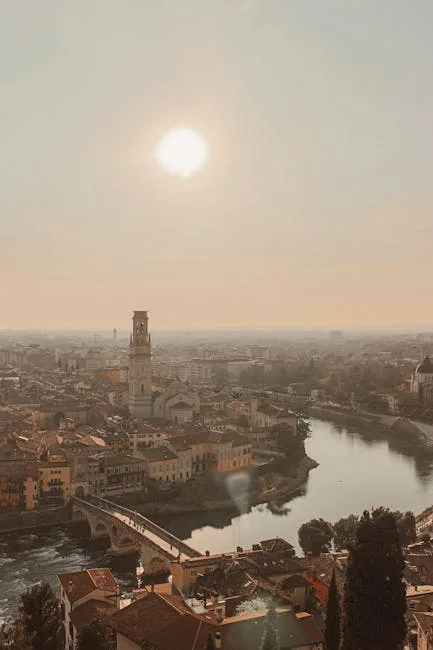 Zon boven de rivier en een toren in Verona
