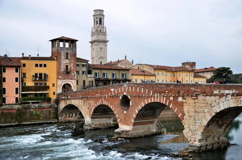 Ponte Pietra mit historischen Häusern und Kirchturm in Verona