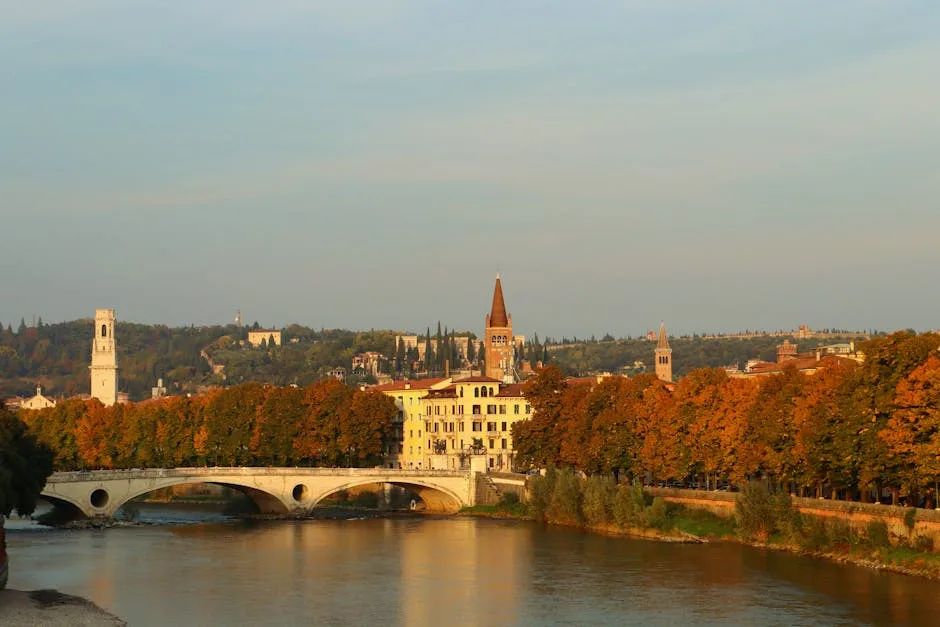 Pont et façades riveraines de Vérone bordés d'arbres aux couleurs automnales
