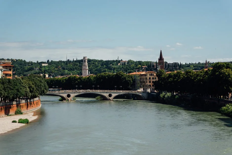 Le pont sur l'Adige à Vérone encadré d'arbres et bâtiments