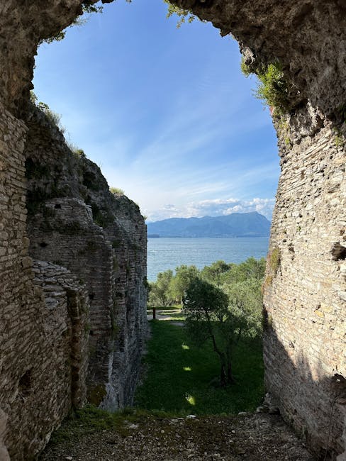 Vue sur le lac de Garde encadrée par une arche dans les ruines de Sirmione