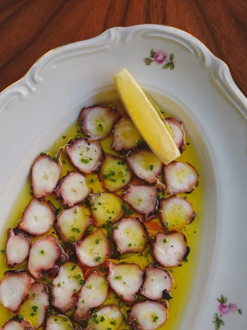Tranches de poulpe nappées d'huile d'olive avec quartier de citron