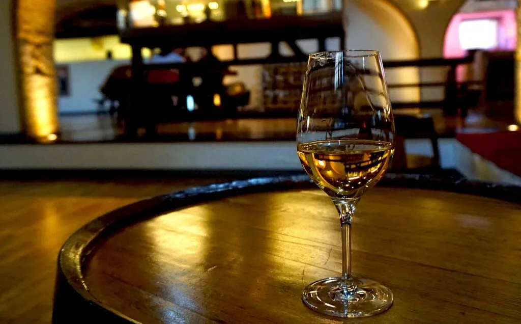 Verre d'eau-de-vie ambrée posé sur un tonneau dans une cave à Vérone
